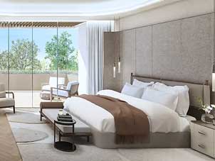 Bright and airy bedroom at Ghaf Woods with large sliding doors leading to a balcony, filling the space with natural light.