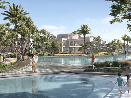 Family-friendly lagoon area at Oasis by Emaar, surrounded by palm trees and modern villas, offering a serene waterfront experience