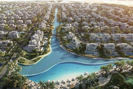 Aerial view of Mirage at The Oasis waterfront villas in Dubai, featuring serene lagoons, a private beach with palm trees, and modern luxury residences.