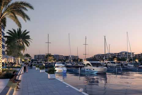 Sunset view of Ora Bayn marina in Ghantoot with yachts, palm trees, and modern buildings