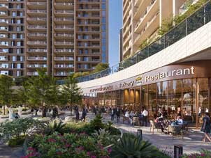 The community retail area at Sidr Residences, featuring cafes, a bakery, and a restaurant, with people walking and dining outdoors.