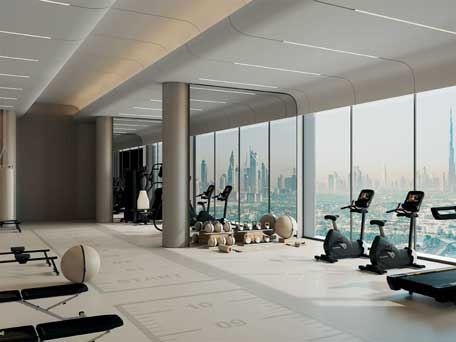 Modern gym at Skyhills Astra with state-of-the-art fitness equipment and a panoramic view of the Dubai cityscape, including the Burj Khalifa.