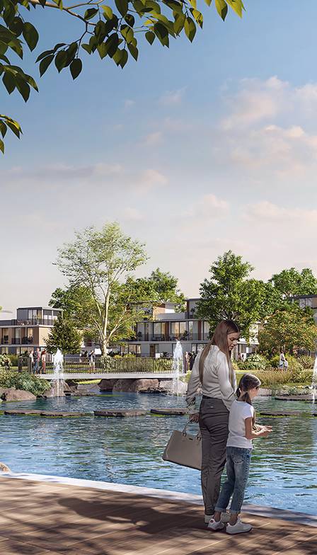 A family-friendly playground at Riviera, The Valley, showcasing children playing and parents interacting in a vibrant and green outdoor space within the residential community